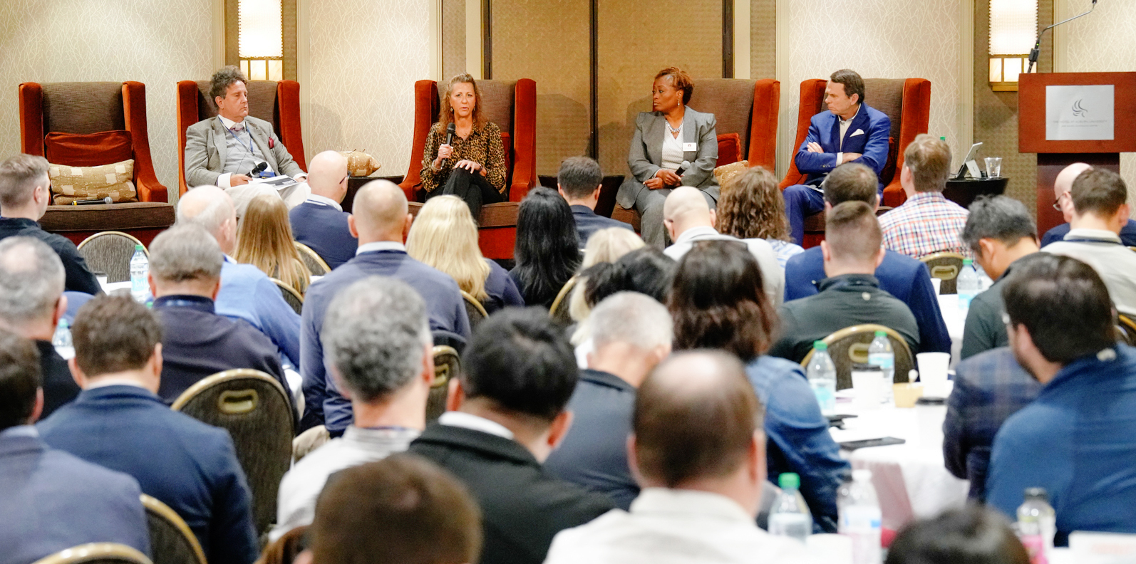 4 speakers seated talking to audience