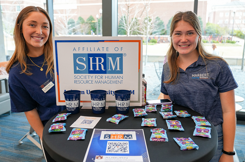 Two students standing at display table