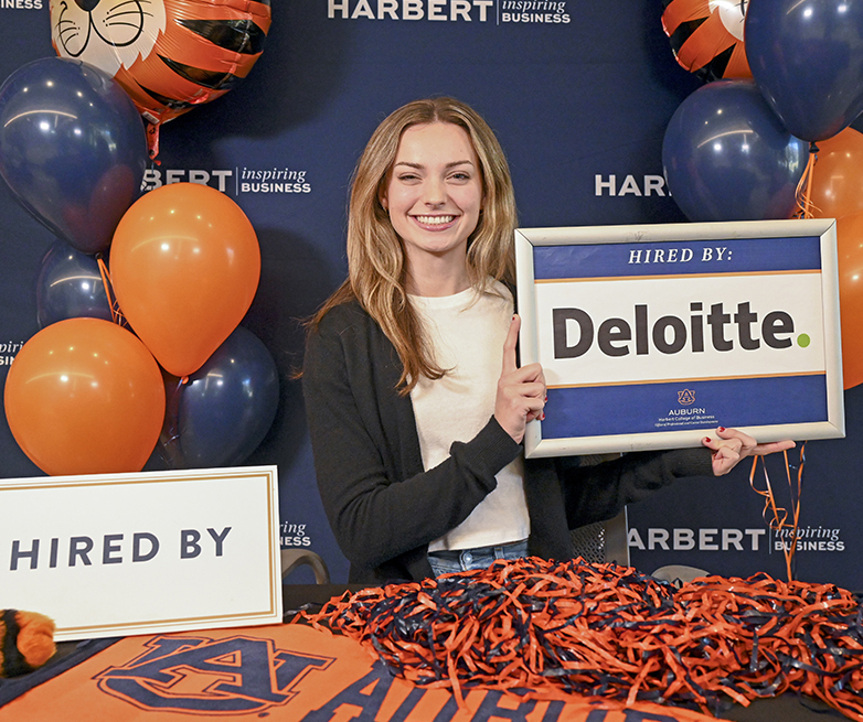 Olivia Stanley holding Deloitte sign
