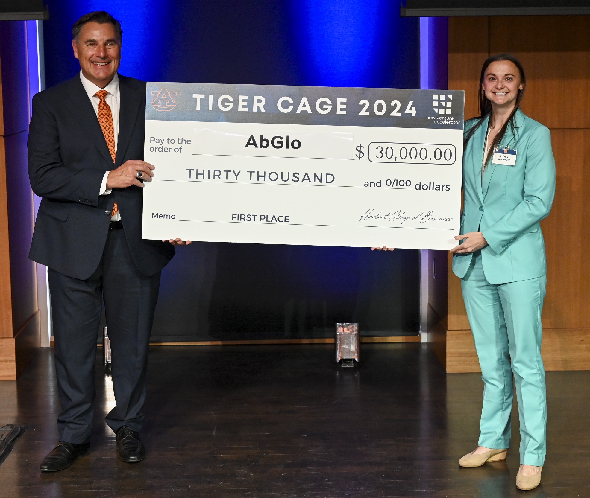 2 people holding giant check