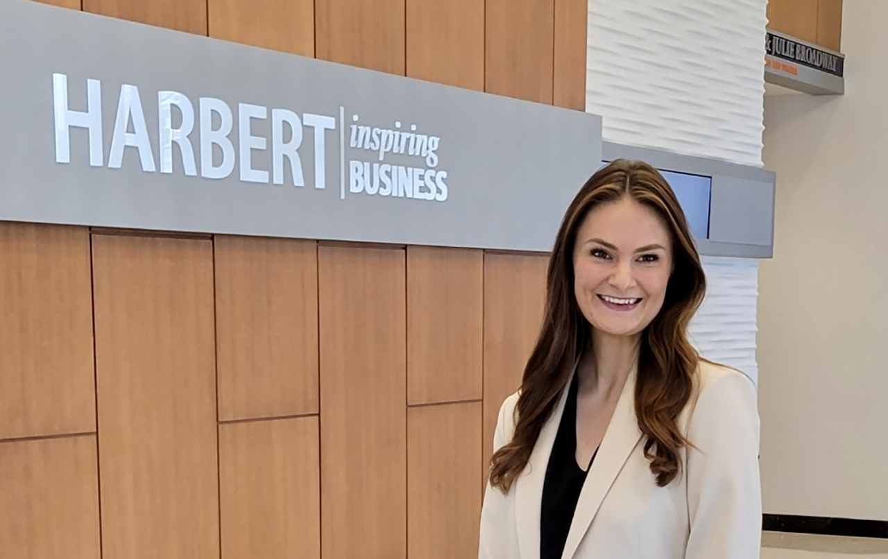 Student standing in front of Harbert sign