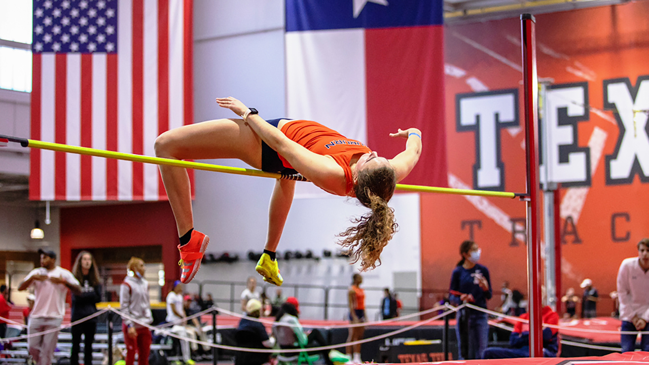 Woman student jumping bar in high jump
