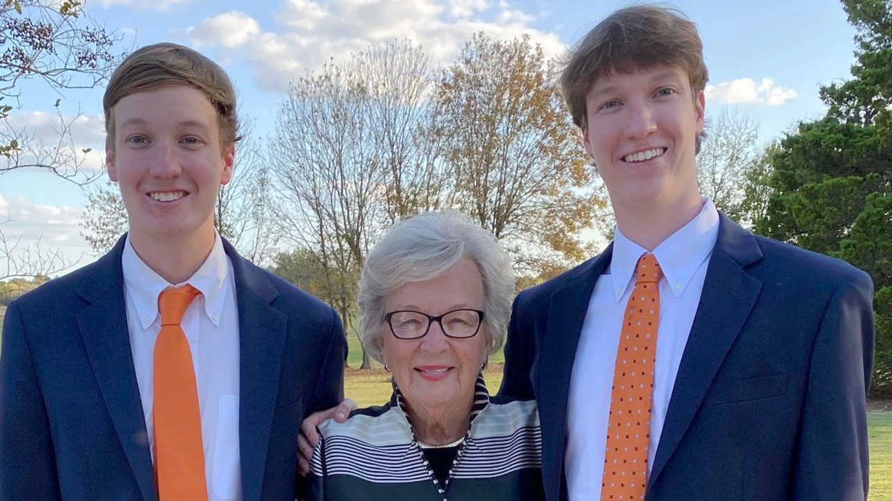 Barbara Crane standing between grandsons