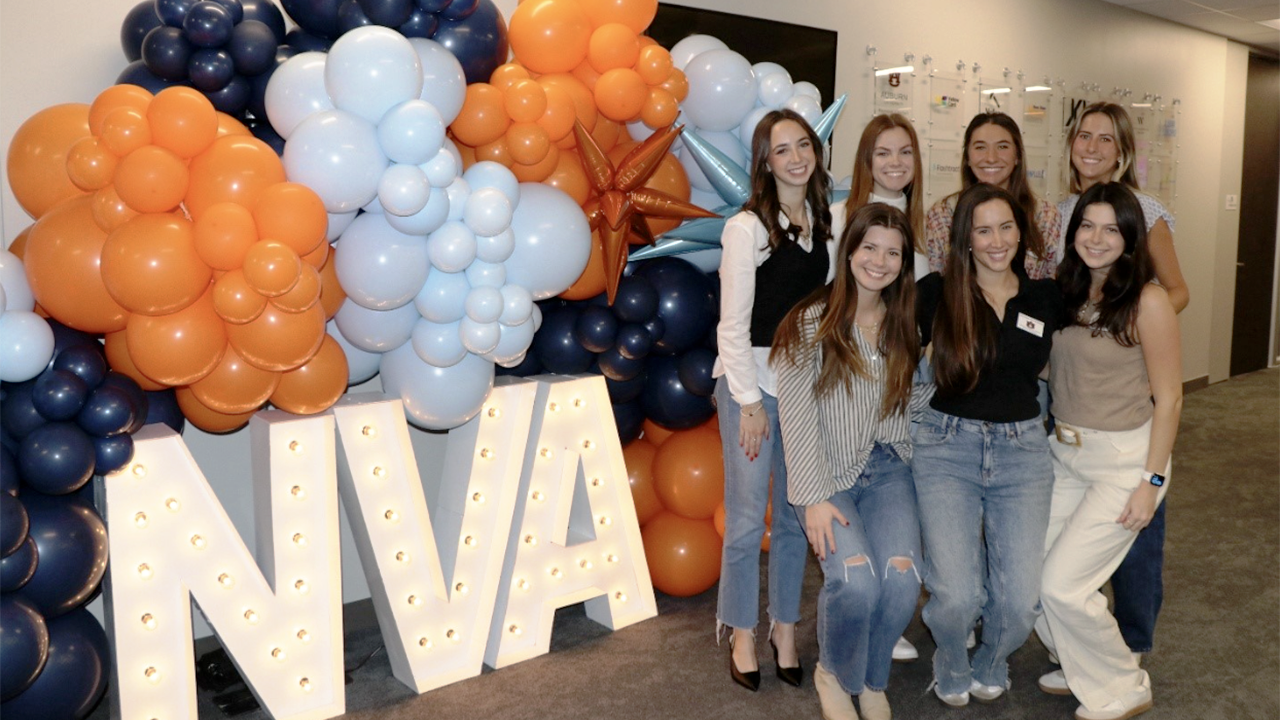 Women students standing by NVA letter sign