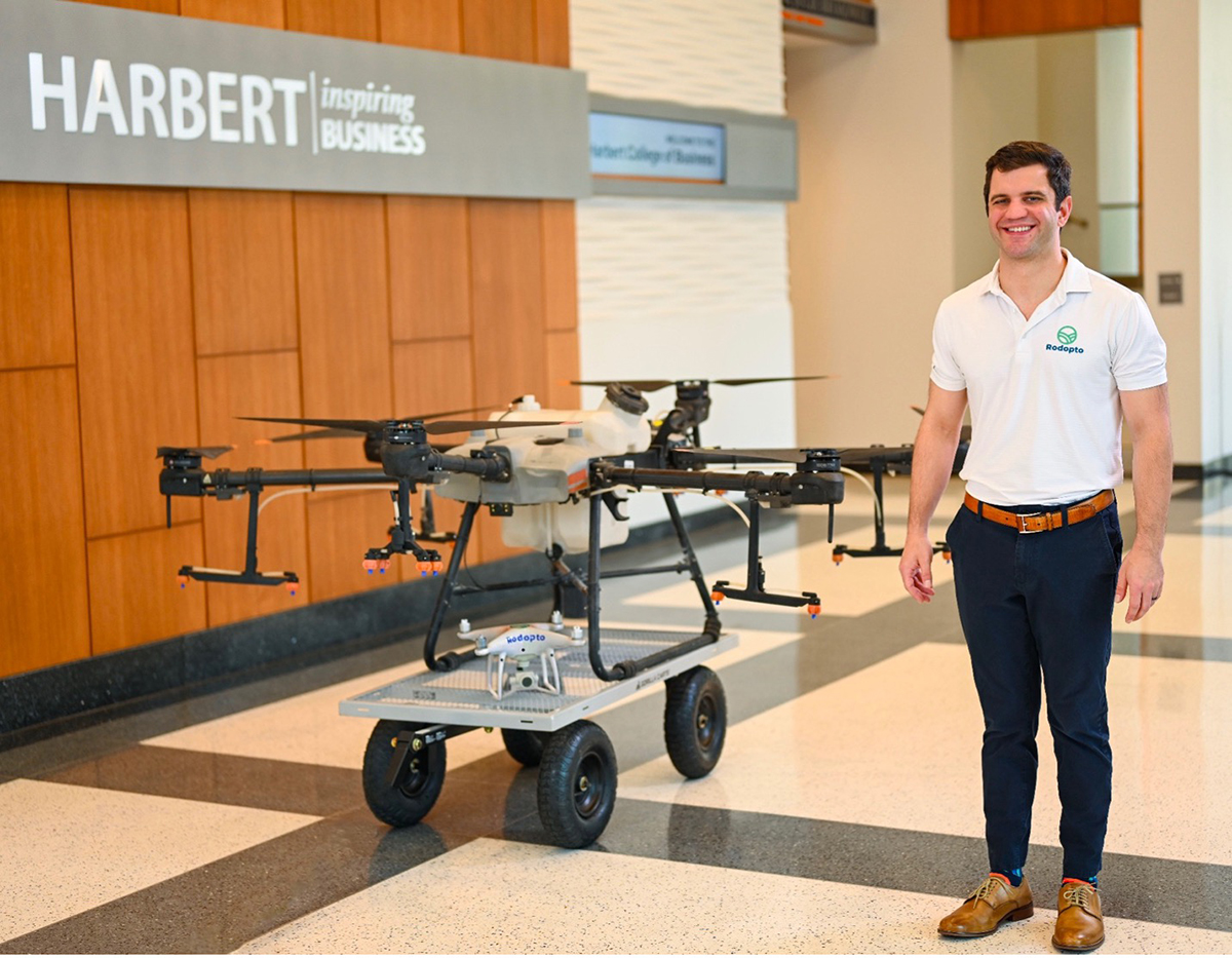 man standing next to drone