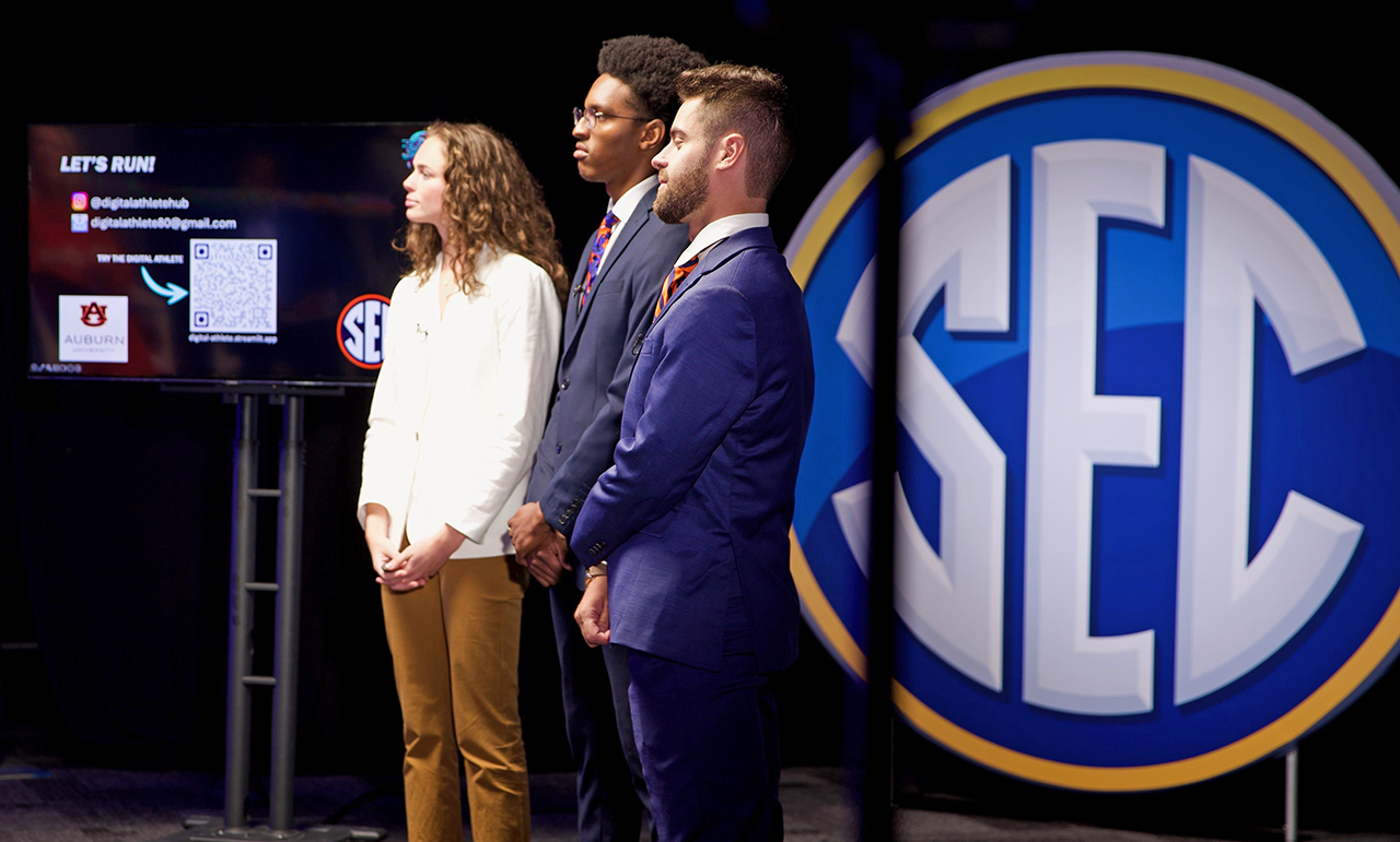 Woman and two men on stage at SEC Startup competition